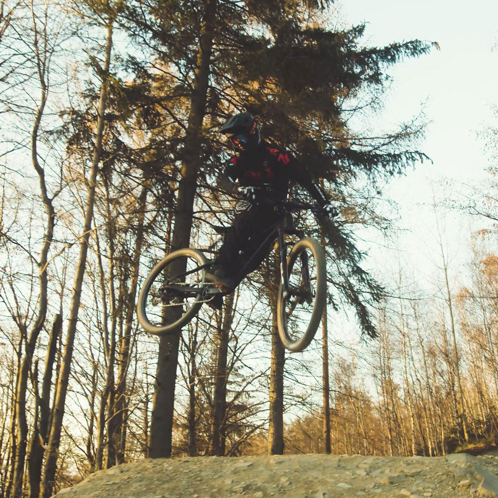 Mountain biker jumping a dirt ramp